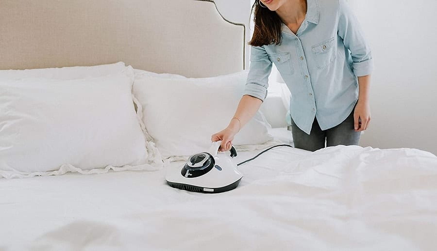 lady using vacuum on her bed