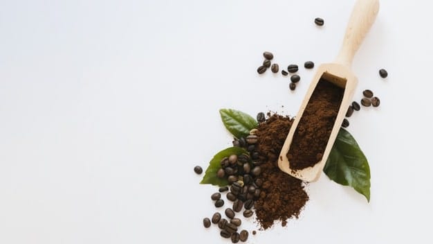 ground coffee in the spoon on the white background