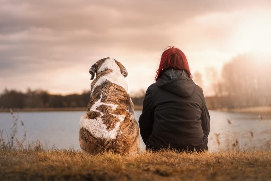 god and woman sitting near the lake