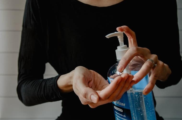 woman uses hand sanitizer